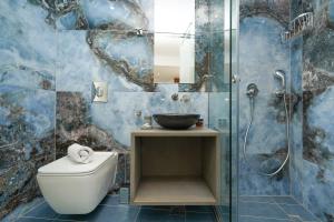 uma casa de banho com um WC e uma cabina de duche em vidro. em Stylish Living-Parthenon em Atenas