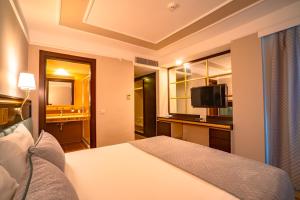 a hotel room with a bed and a television at Royal Atlantis Spa & Resort in Side
