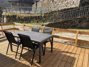 una mesa y cuatro sillas en una terraza en L’atelier d’Auguste, en Marcols-les-Eaux