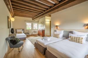 1 dormitorio con 2 camas y 1 silla en Locations - Domaine Le Coq Enchanté en Cambremer