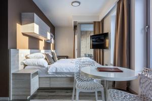 pokój hotelowy z łóżkiem, stołem i krzesłami w obiekcie HOTEL PECR DEEP w mieście Pec pod Sněžkou