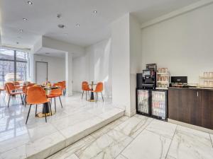 a dining room with orange chairs and a table at Triple G Hotels in Amsterdam