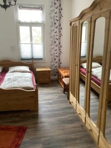 Un dormitorio con dos camas y un espejo. en Schöne Ferienwohnung, en Eisenach