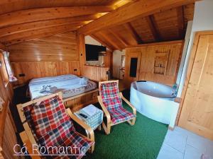 a room with a tub and two chairs and a bed at Romantic Spa in Venas