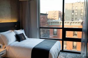 ブルックリンにある42 Hotel Williamsburgのベッドルーム1室(ベッド1台、大きな窓付)