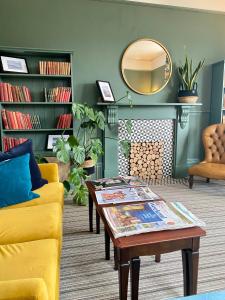 a living room with a yellow couch and a coffee table at The Emsworth B&B Hotel in Emsworth