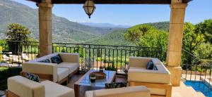 a porch with couches and a view of mountains at Loup Castel Boutique Hotel B&B in Le Bar-sur-Loup