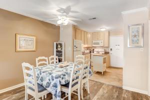 a dining room with a table and chairs and a kitchen at Fiddlers Cove 22J in Hilton Head Island
