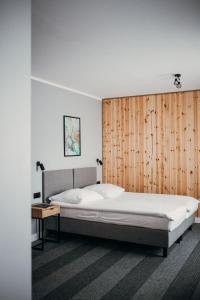 Bursztynowy Sen Stegna في ستيغنا: غرفة نوم بسرير كبير وجدار خشبي