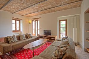 een woonkamer met een bank en een salontafel bij Villa Collina by PosarelliVillas in Montegiove