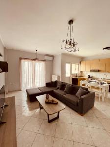 a living room with a couch and a table at SunRise Apartment near Airport in Spata