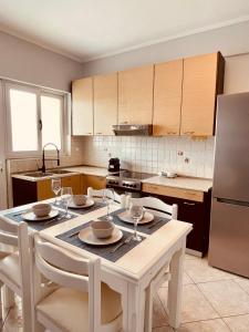 a kitchen with a table with chairs and a refrigerator at SunRise Apartment near Airport in Spata
