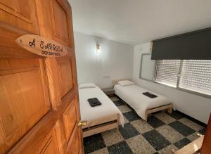 a small room with two beds and a door at Grip Surf Beach House Corrubedo in Corrubedo