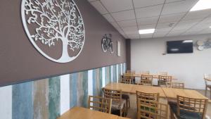 a classroom with tables and chairs and a tree mural on the wall at Hotel Rural Cor De Prades in Mont-ral
