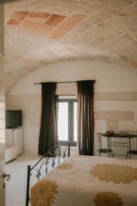 a bedroom with a bed with aamed ceilings and a window at Le Camporelle In Città in Lecce