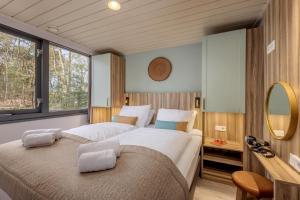 a bedroom with two beds and a mirror at Center Parcs De Kempervennen Eindhoven in Westerhoven