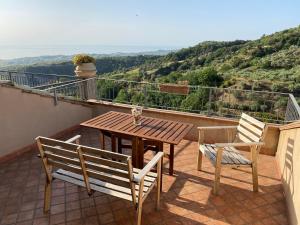 a wooden table and chairs on a balcony with a view at Slow holidays in Calabria tradizioni eno-gastonomia tra borgo e mare in Badolato