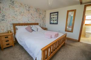 une chambre avec un lit avec des serviettes roses dessus dans l'établissement Bramblewood Cottage, à Crookdake