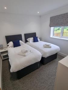 two beds sitting next to each other in a bedroom at Fairway View Cottage in Rothbury
