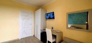 a room with a desk and a television on the wall at I Fichi D'India Rooms in Capo Vaticano
