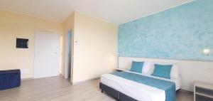 1 dormitorio con cama y pared azul en I Fichi D'India Rooms en Capo Vaticano