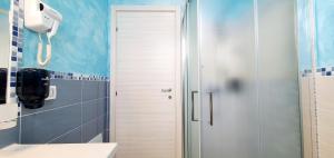 a bathroom with a shower and a white door at I Fichi D'India Rooms in Capo Vaticano