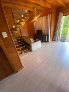 ein Wohnzimmer mit einer Treppe in einem Haus in der Unterkunft Chalé Guest House in Urubici