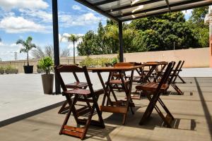 uma mesa de madeira e cadeiras num pátio em Hotel Plaza Garden em Cascavel