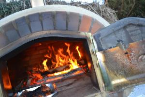 a brick oven with a fire in it at East Thorne Glamping in Bude