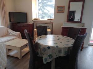 Montcuq的住宿－Le Tuquet，客厅配有桌椅和电视。