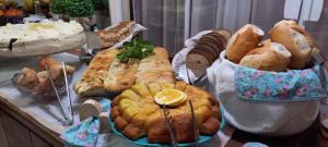 a bunch of different types of bread and pastries on a table at Pousada Recanto Feliz in Penha