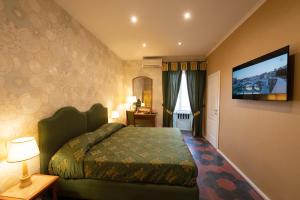 ein Hotelzimmer mit einem Bett und einem Flachbild-TV in der Unterkunft Venus Inn B&B Rome in Rom