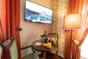 Zimmer mit einem Tisch und einem TV an der Wand in der Unterkunft Venus Inn B&B Rome in Rom
