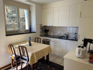 Ascona: Casa Rivabella في أسكونا: مطبخ مع طاولة عليها قطعة قماش