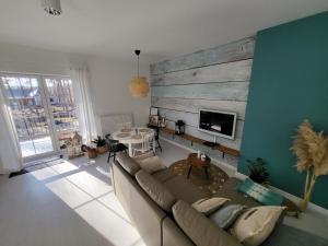 salon z kanapą i drewnianą ścianą w obiekcie APARTAMENT przy jeziorze w Bornem-Sulinowie