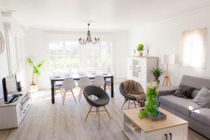 ein Wohnzimmer mit einem Sofa und einem Tisch mit Stühlen in der Unterkunft Jolie maison pour 8 personnes in Plobannalec-Lesconil