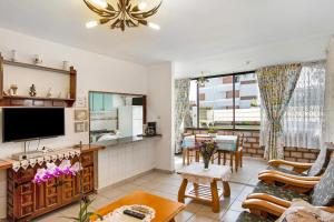 a living room with a tv and a couch and a table at Casa Alegria 2 in Maspalomas