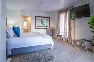 a bedroom with a white bed and a flat screen tv at Chateau de Marine Boutique Hotel in Struisbaai +104 photos
