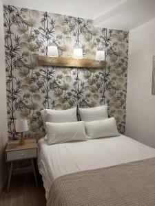 a bedroom with a white bed with a floral wallpaper at Perpignan Vauban magnifique T2 avec balcon in Perpignan
