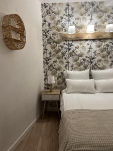 um quarto com uma cama e uma parede com papel de parede em Perpignan Vauban magnifique T2 avec balcon em Perpignan