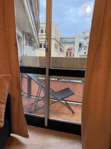 a view of a balcony with a chair through a window at Perpignan Vauban magnifique T2 avec balcon in Perpignan