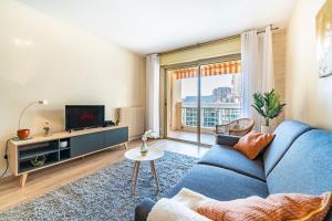 un salon avec un canapé bleu et une télévision dans l'établissement 50m de Monaco, Grimaldi forum, Larvotto Beach - AI, à Beausoleil