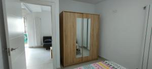 a wooden cabinet with a mirror in a room at Casa Carmen 1 in Cudillero