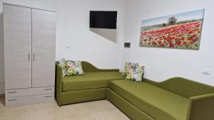 uma sala de estar com um sofá verde e um quadro em Al Civico 365 em Castelluzzo