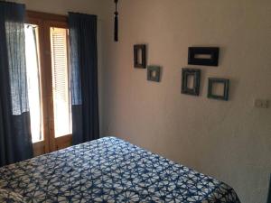 1 dormitorio con cama con colcha azul y ventana en El Raconet de Dénia, en Denia