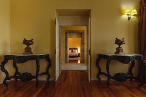 two tables in a room with a bedroom at Glicínia Boutique Hotel in Freamunde