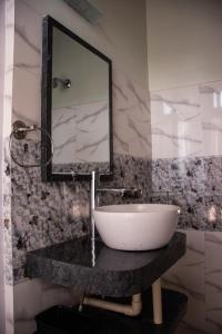 W łazience znajduje się umywalka i lustro. w obiekcie The Arcadia Resort - Umroi w mieście Shillong
