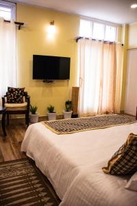 1 dormitorio con 1 cama grande y TV de pantalla plana en The Arcadia Resort - Umroi en Shillong