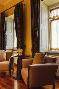 a living room with two chairs and a table at Glicínia Boutique Hotel in Freamunde