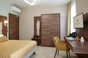 ein Hotelzimmer mit Bett und Schreibtisch in der Unterkunft Hotel Spigamonti in Negrar